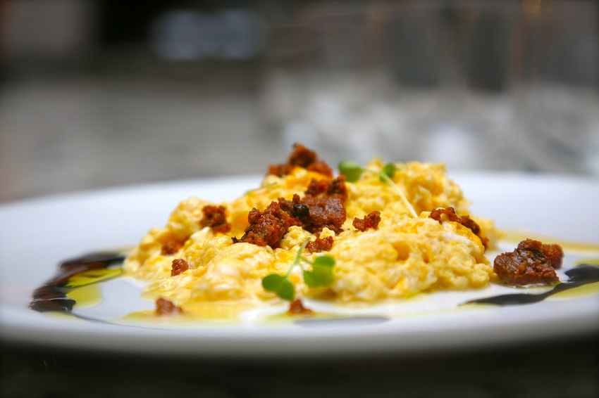 Huevos rotos, oricios (erizos de mar) y salsa de chipirones