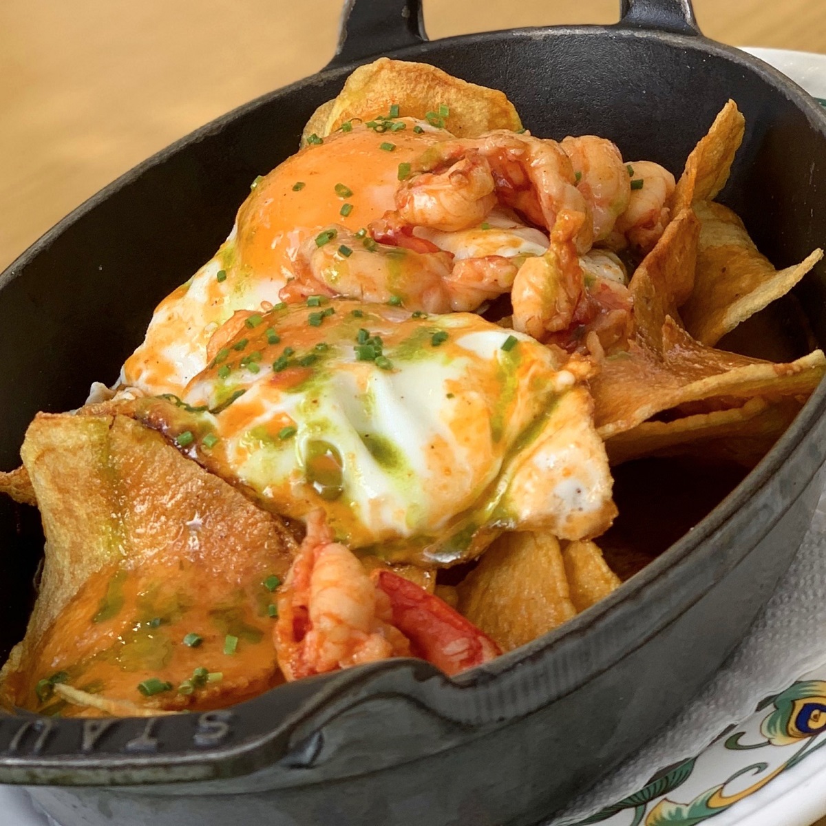 Huevos rotos con carabineros, patatas encebolladas, salsa de su propio jugo y piquillos