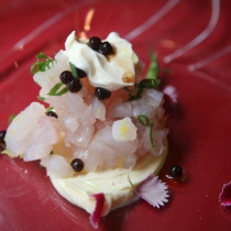 Caballa en tartar con huevas de trucha sobre blinis de patata y olivas